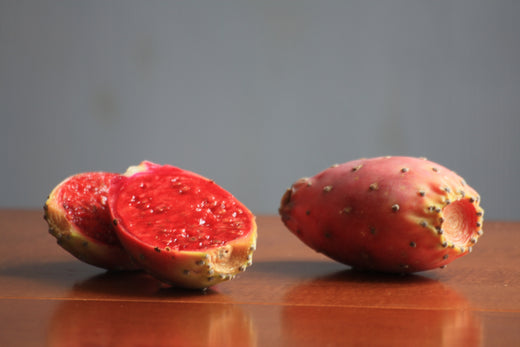 Des figues de barbarie posé sur une table dont une ouverte en deux pour montrer ses pépins