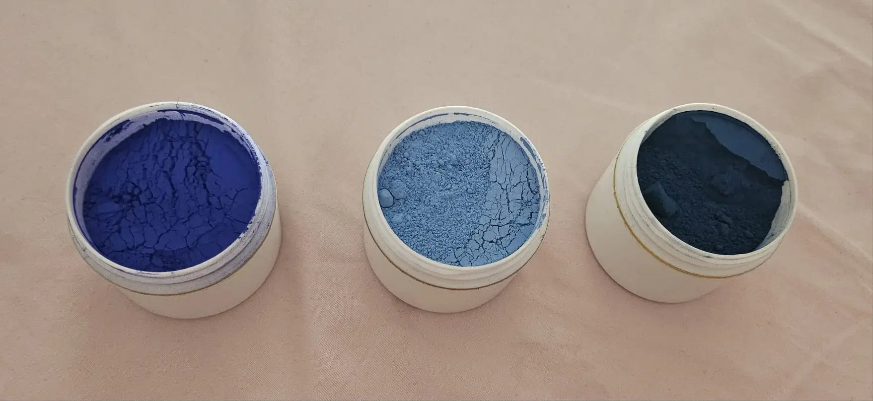 Trois poudres de nila bleu achetées chez trois vendeurs d'un souk marocain
