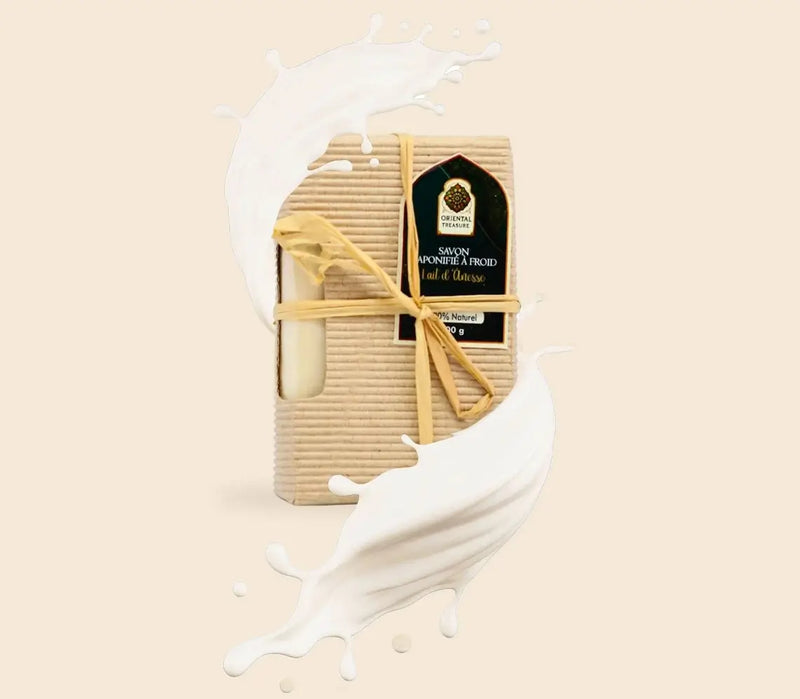 Savon solide saponifié à froid au lait d'ânesse naturel entouré de lait d'ânesse sur fond beige