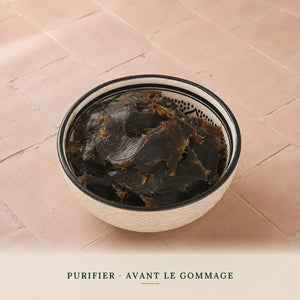 Savon noir nature à la fleur d'oranger dans un bol marocain, texture brun-noir
